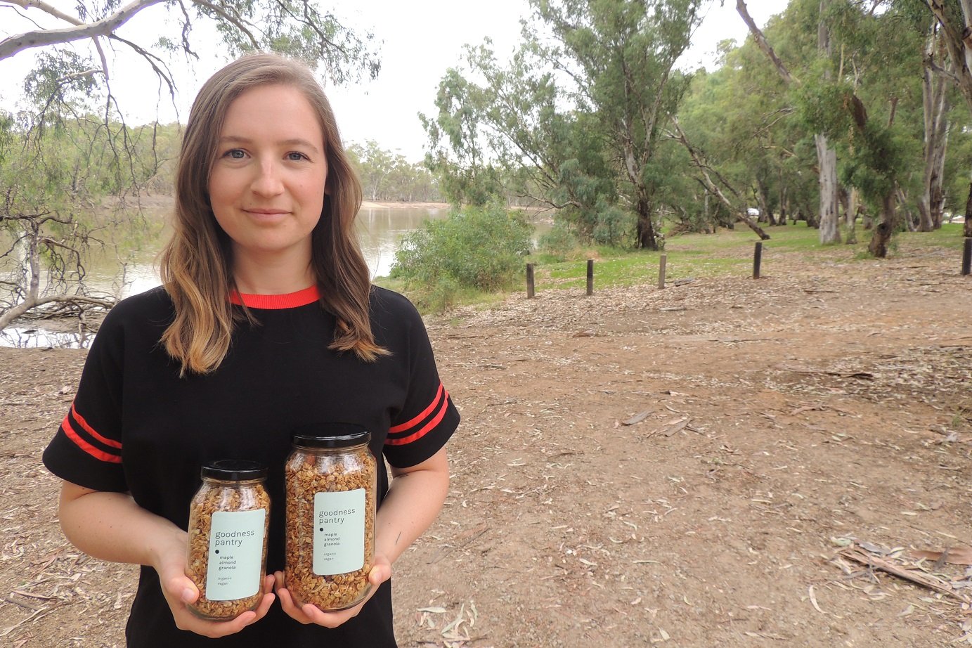 Pic of Erin holding her produce in front of the Murray River