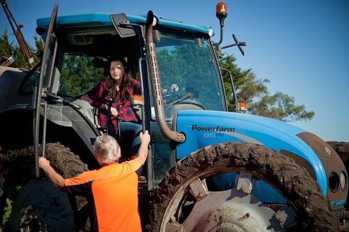 Woman in tractor talking to man