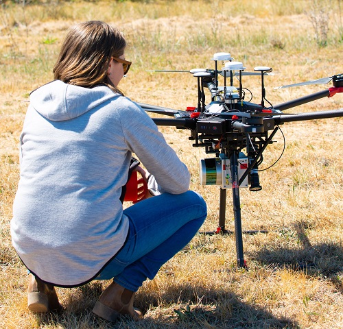 Woman sitting with back to camera operating drone