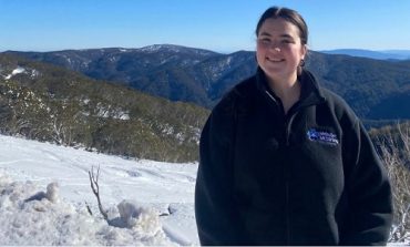 University graduate Annabel stands on top of a snowy mountain