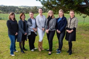 Claire Moore, 2019 AgriFutures Victorian Rural Women's Award winner stands in a field with six other state award finalists