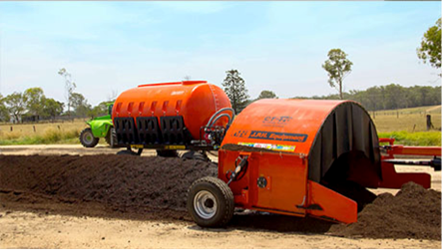 Photo of a windrow turner connected to a mobile water tank.