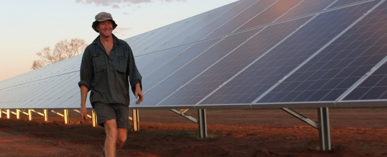 Man walking next to solar panels