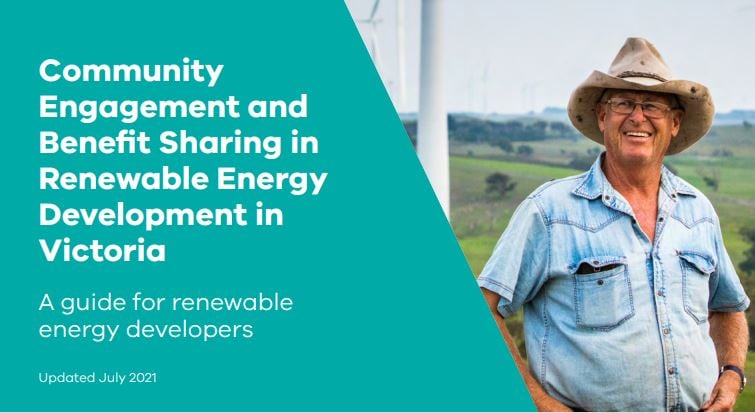 Image of farmer smiling in front of a wind turbine