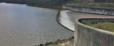 Image of a dam in Gippsland with water flowing over the spillway