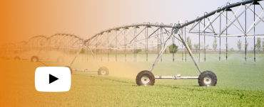 Pivot irrigation machine with orange wash over it and play button