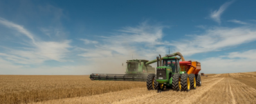 Combine harvester and tractor with chaser bin harvesting a cereal crop