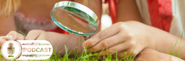 Children with magnifying glass in the grass