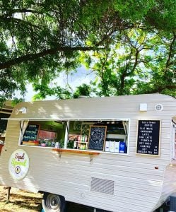image of a food van parked under leafy green tree