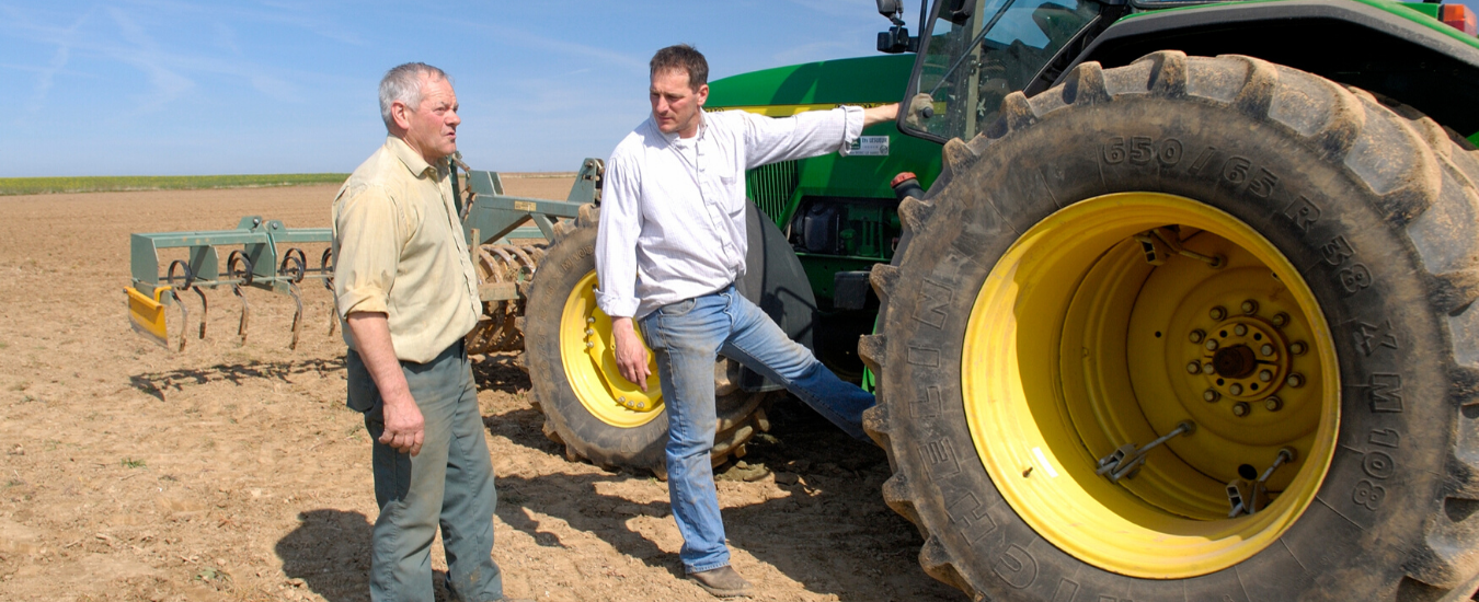 Two farmers talking at a tractor in a paddock